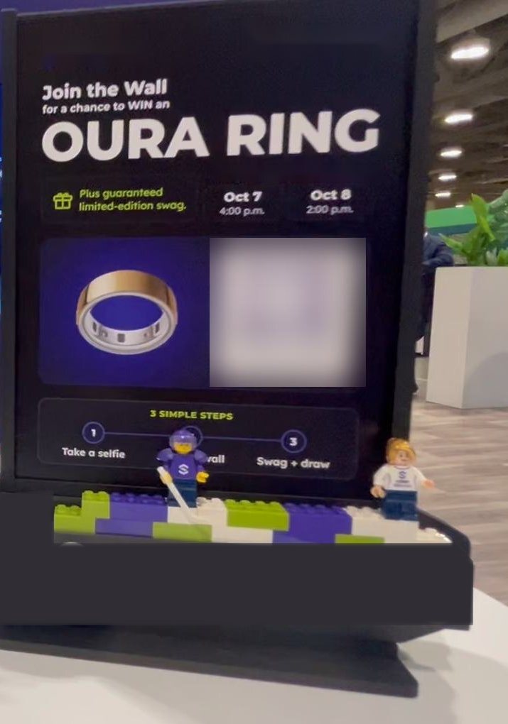 A stand at the booth: Join the Wall for a chance to win an Oura Ring, with LEGO minifigures.